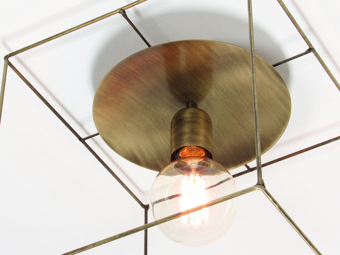 Modern ceiling light fixture with a bronze cubic frame and bronze center disc
